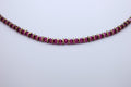 Necklace with magenta gemstones on a light gray background