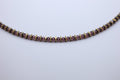 Necklace with purple merlot beads and gold accents on a light gray background