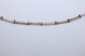 Necklace with pink beads and gold accents on a light gray background