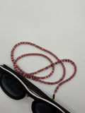 Sunglasses with a beaded lanyard on a light gray background