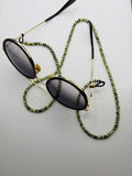 Sunglasses with a beaded chain on a light gray background