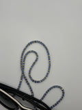 Blue beaded eyeglasses strap on a gray surface